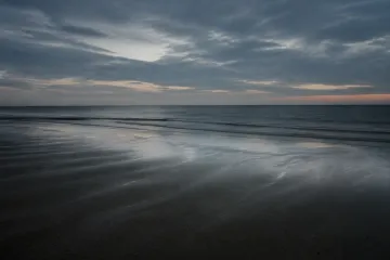 Lege Noordzeekust onder een gedempte blauwe lucht