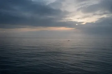 Donkere golven aan een winterse kust met een verlaten badtrap
