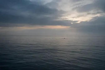 Donkere golven aan een winterse kust met een verlaten badtrap